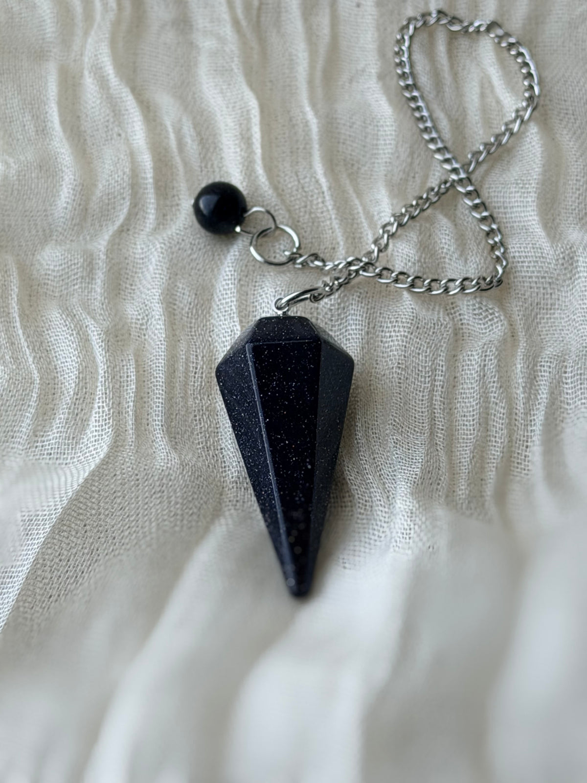 Pendel van blauwe goudsteen met glinsterende puntjes aan een ketting