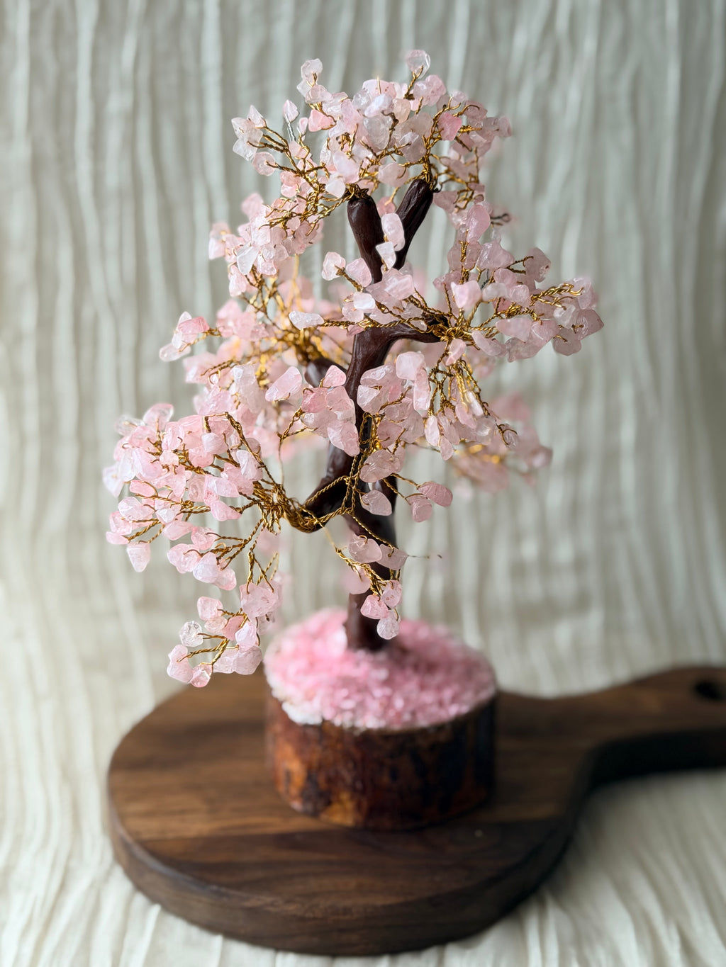 Handgemaakte rozenkwartsboom met roze steentjes op een houten voet