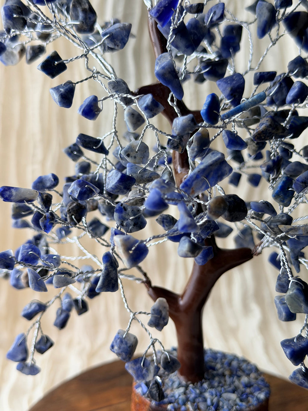 Handgemaakte sodalietboom met blauwe steentjes op een houten voet