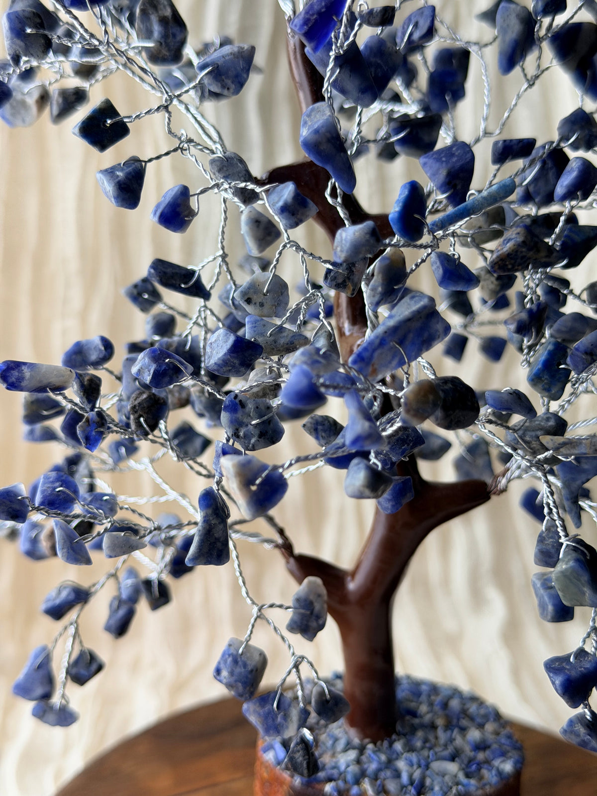 Handgemaakte sodalietboom met blauwe steentjes op een houten voet