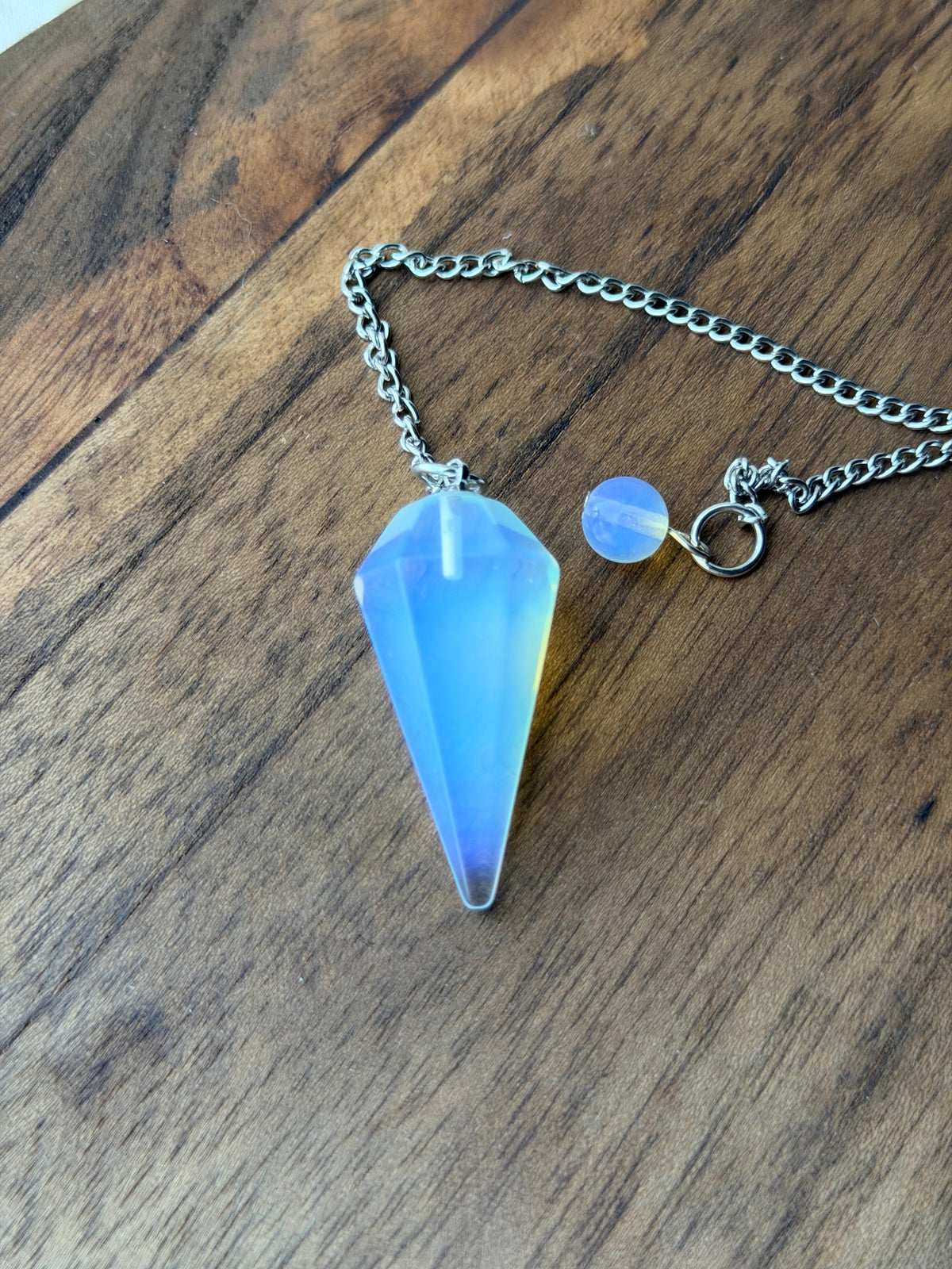 Pendel van opaliet met zachte blauwe glans aan een ketting