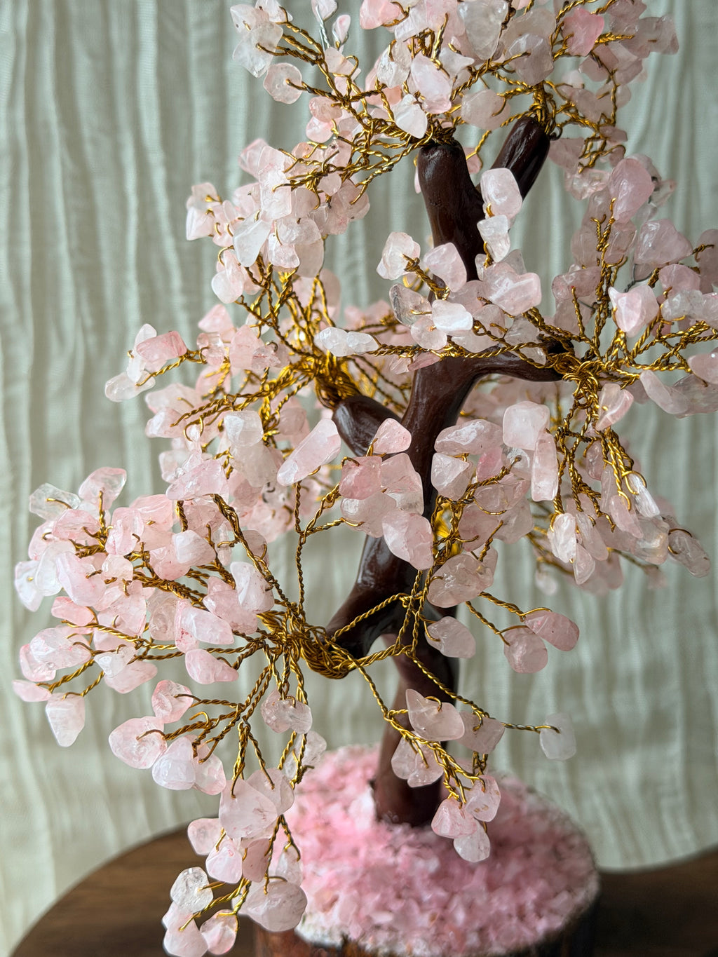 Handgemaakte rozenkwartsboom met roze steentjes op een houten voet