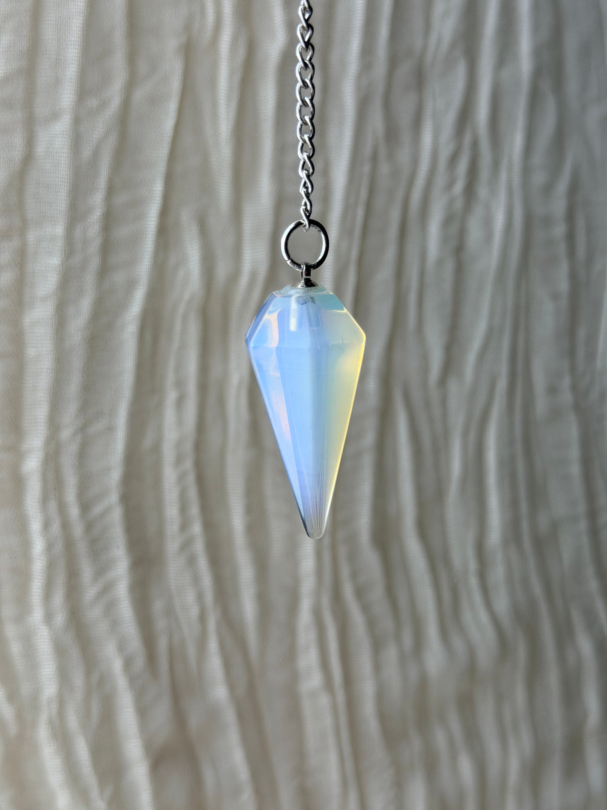 Pendel van opaliet met zachte blauwe glans aan een ketting