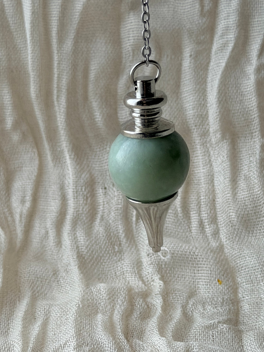 Bolvormige pendel van groene jade aan een ketting
