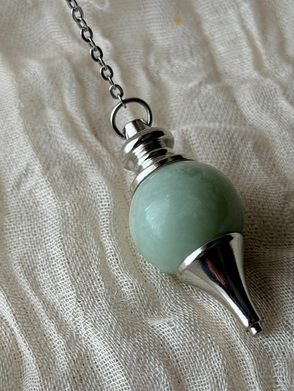 Bolvormige pendel van groene jade aan een ketting