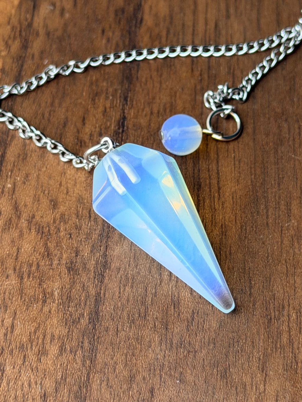 Pendel van opaliet met zachte blauwe glans aan een ketting