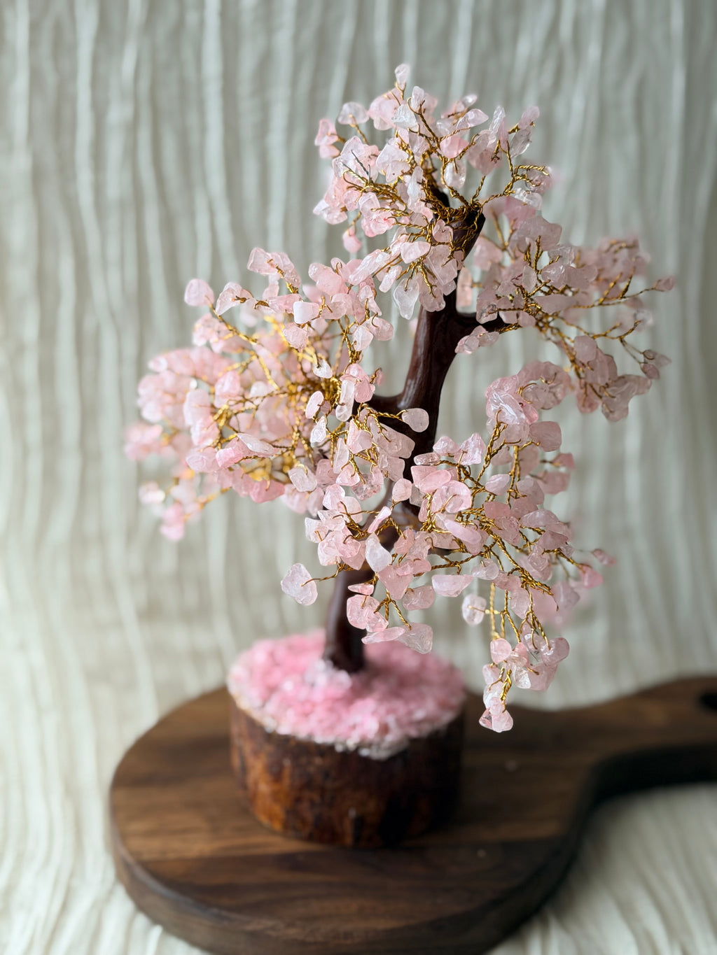 Handgemaakte rozenkwartsboom met roze steentjes op een houten voet